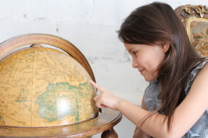 Child looking at globe earth with smiling face